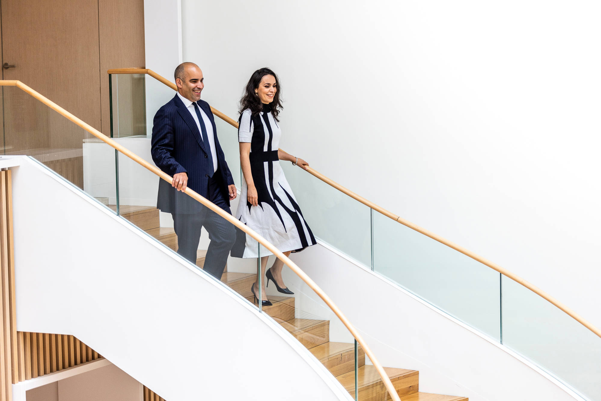 Male and Female Lazard Colleagues Walk Down Set of Stairs